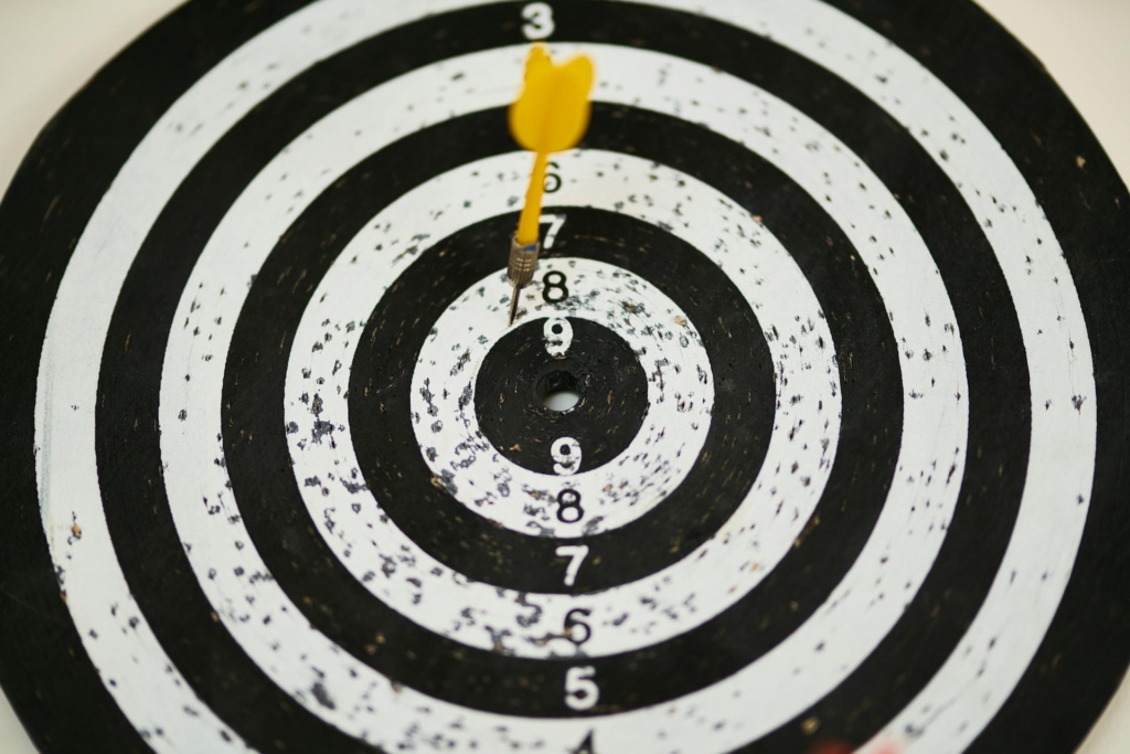A dartboard with a yellow dart in the white circle.