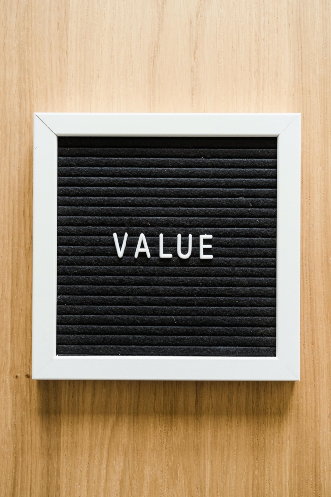A sign sits on a wooden wall that reads "Value"