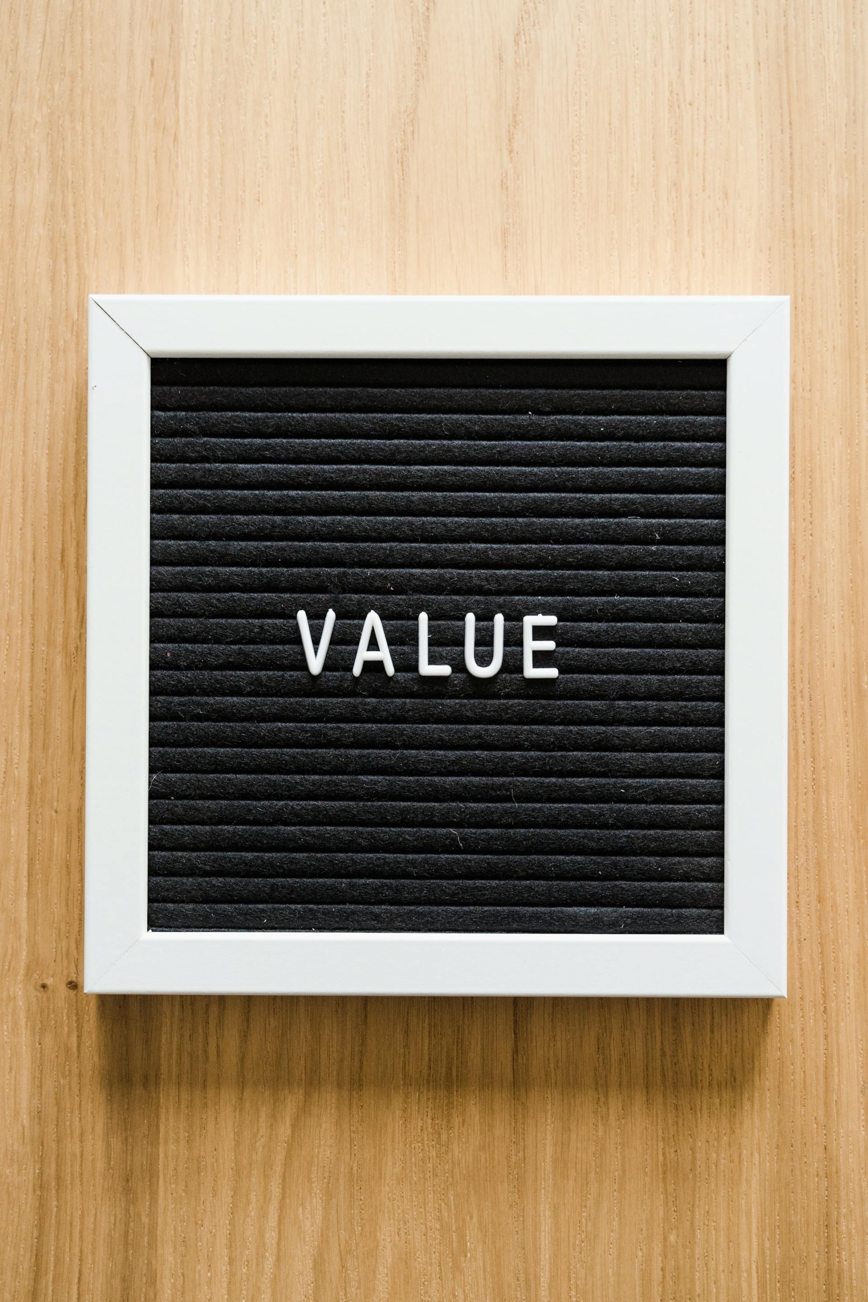 A sign sits on a wooden wall that reads "Value"