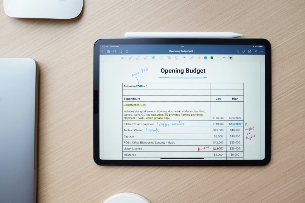 An iPad sits on a table with a personal budget on the screen.