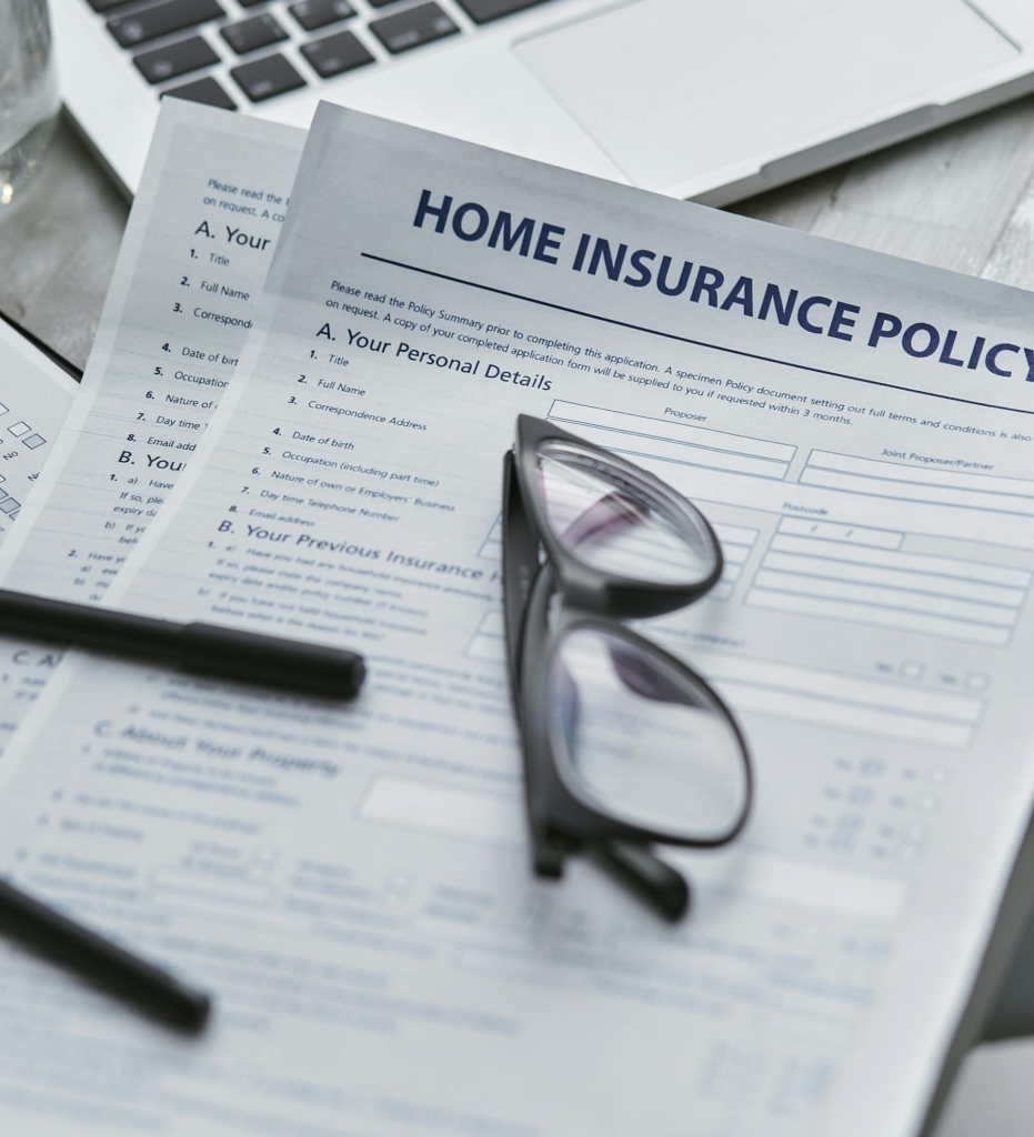 A pair of glasses sits on top of a home insurance policy.
