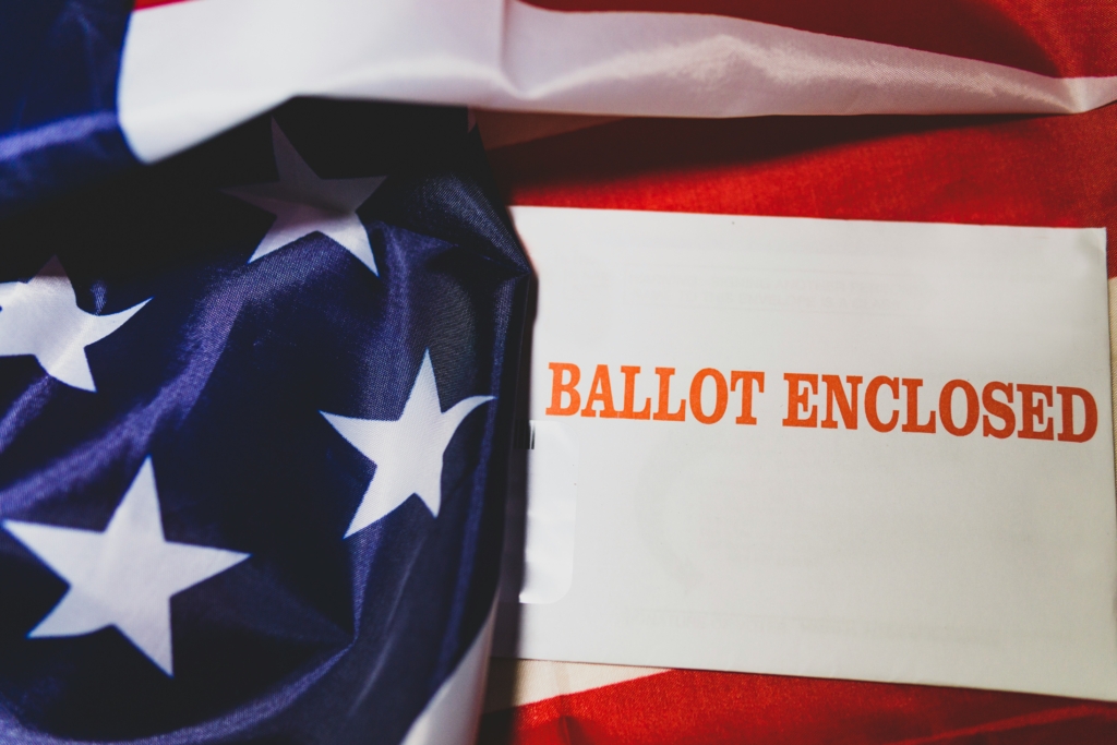 An image of an American flag with sign reading "Ballot Enclosed"