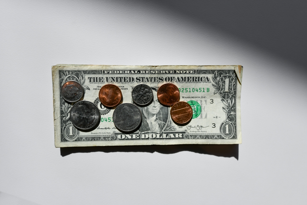 A dollar bill with coins on top of it