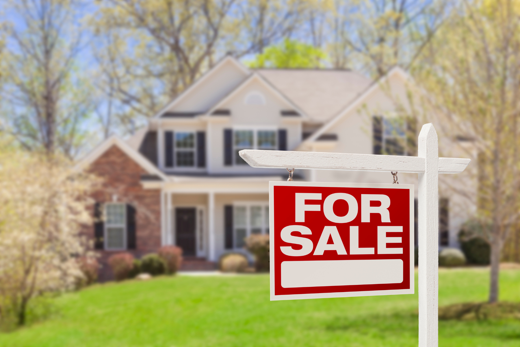 A home with a for sale sign in front of it.