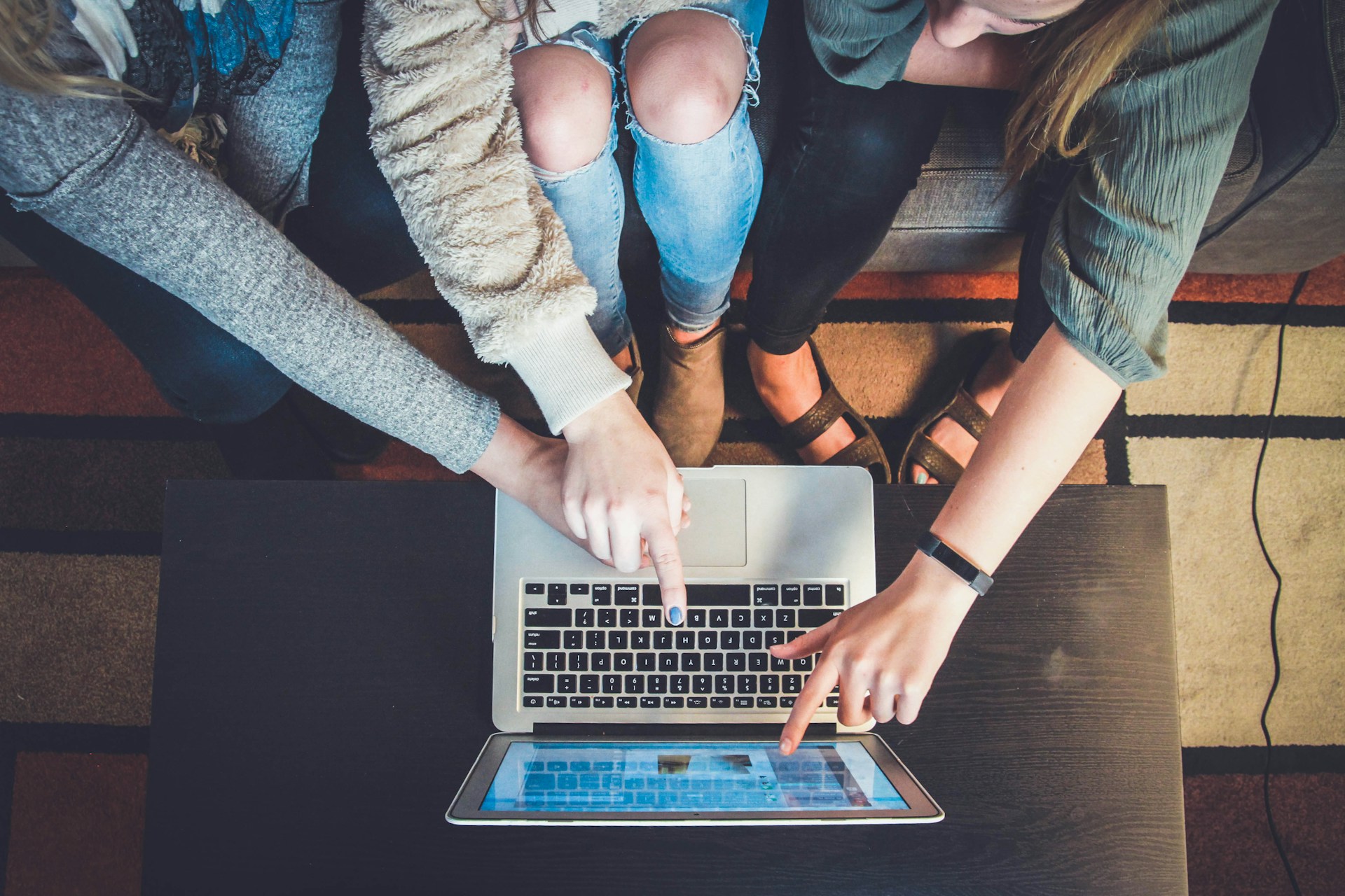 People collaborating and pointing at a laptop screen.