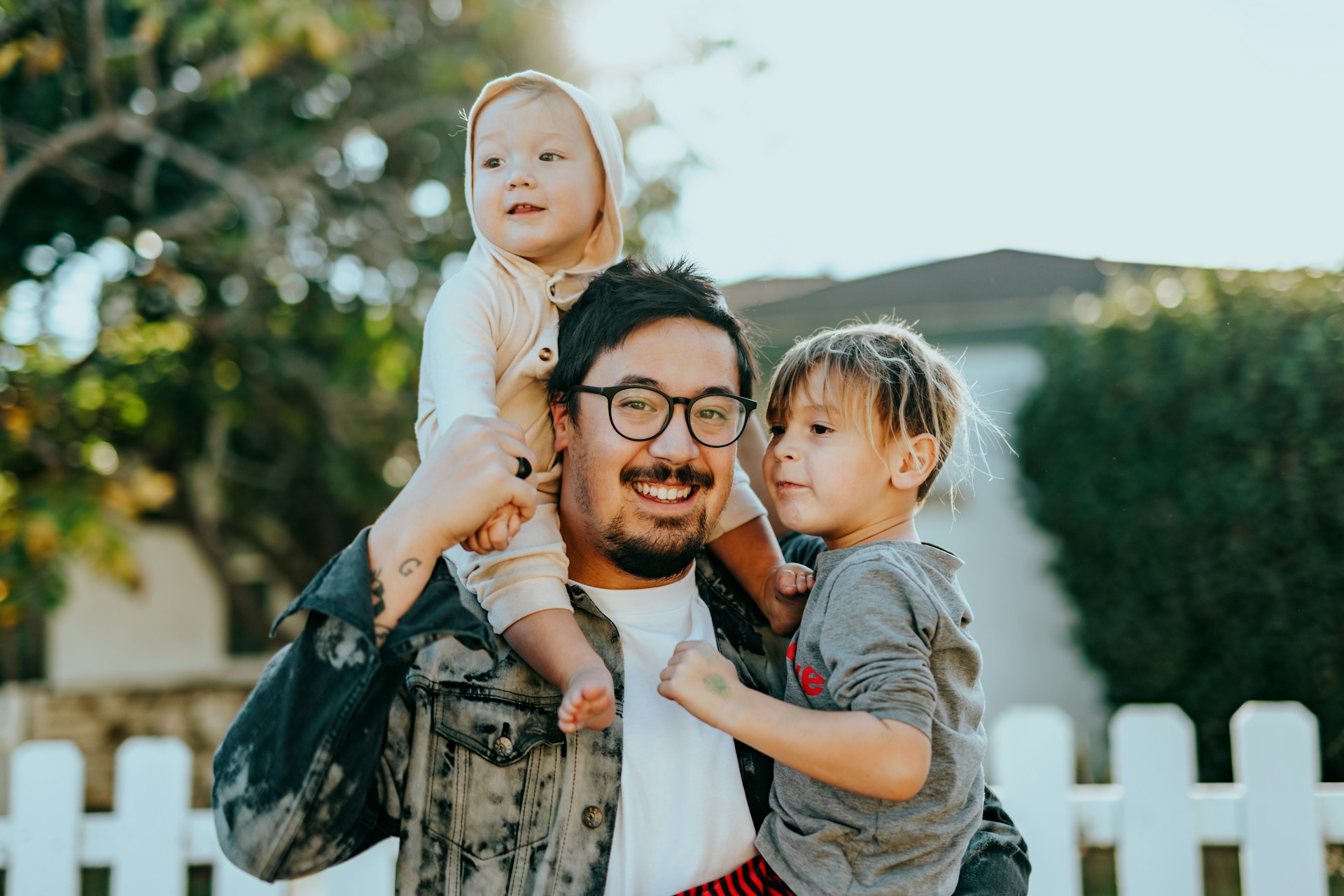 Man in white shirt carrying girl in gray shirt