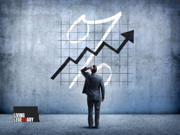 A man stands in front of a graph with a percentage sign.